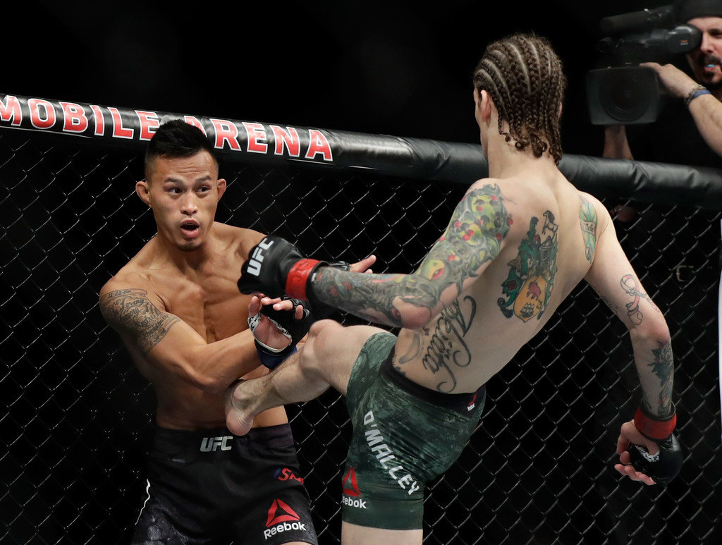 Sean O'Malley (R) kicks Andre Soukhamthath during their bantamweight bout during UFC 222