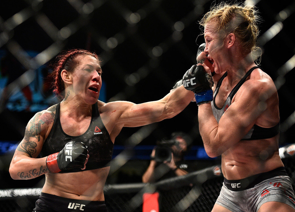 Cris Cyborg of Brazil punches Holly Holm in their women's featherweight bout during the UFC 219 event