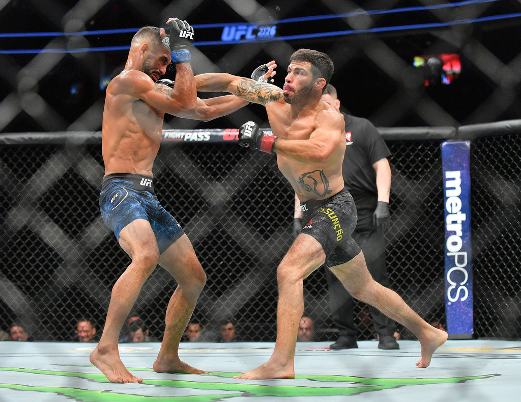 Raphael Assuncao (R) lands a punch against Rob Font during their bantamweight fight at T-Mobile Arena on July 7, 2018 in Las Vegas, Nevada. Assuncao won by unanimous decision.