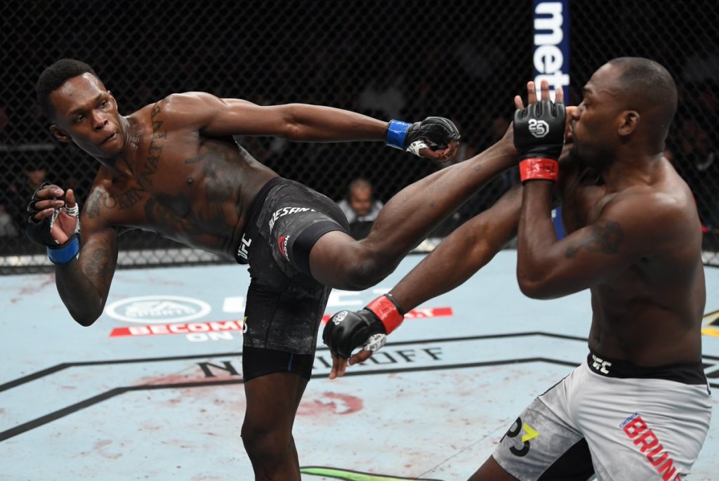 Israel Adesanya smashes Derek Brunson with a left kick