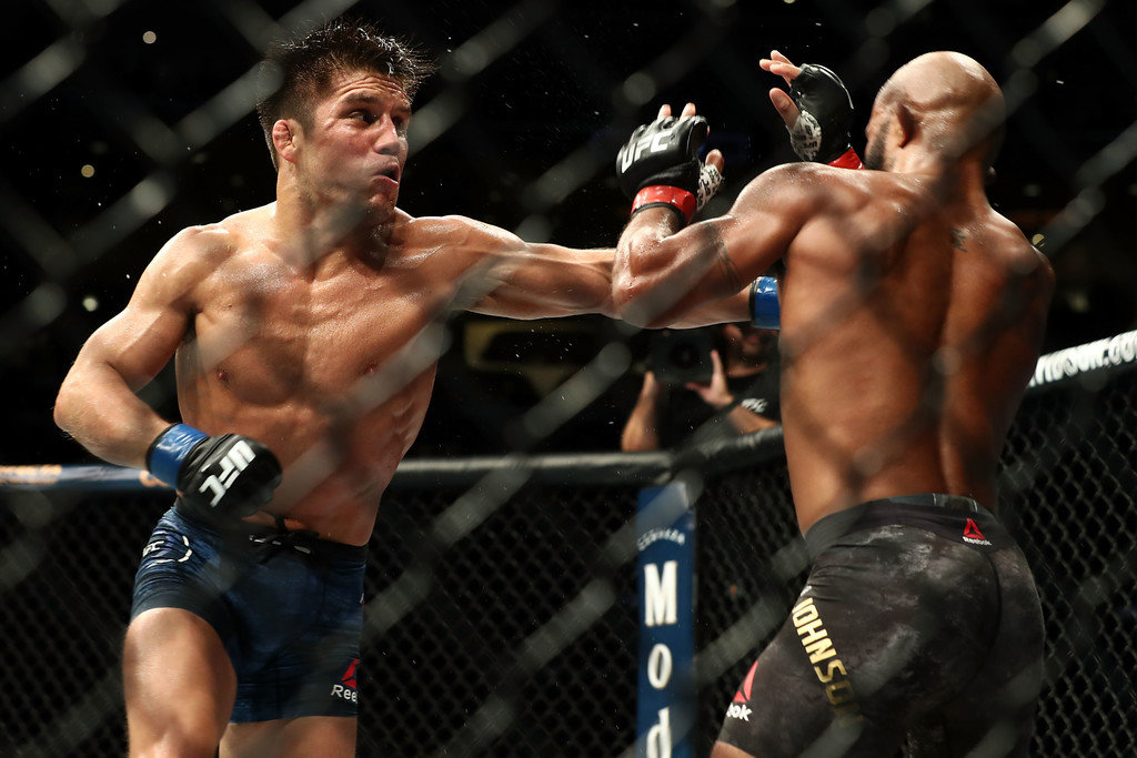 Henry Cejudo punches Demetrious Johnson in the third round of the UFC Flyweight Title Bout during UFC 227