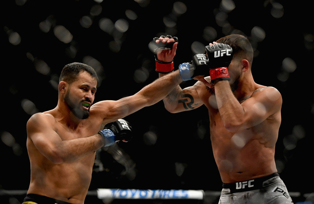 Jussier Formiga of Brazil (L) punches Sergio Pettis (R) in their flyweight bout during the UFC 229 event