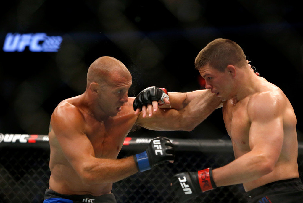 Donald Cerrone (L) battles with Rick Story during their welterweight bout at the UFC 202 event